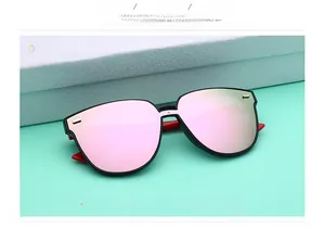 Détail de lunettes de soleil TR polarisées oversize avec verres miroirs roses et branches rouges