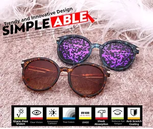 Detail view of round sunglasses with marble and tortoiseshell frames on a soft pink rug