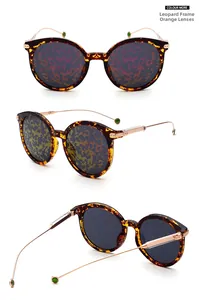 Detail view of retro leopard print round sunglasses with orange lenses and metal temples