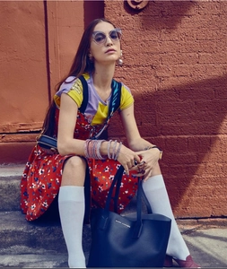Detail van straatmode met een met diamanten bezette cat-eye zonnebril en een draagtas