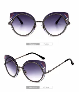 Cat-eye zonnebril met paarse verloopglazen en gedraaid montuur met strass-steentjes