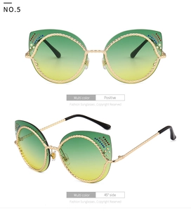 Detail van cat-eye zonnebril met goudkleurig metalen touwframe en kleurrijke stras