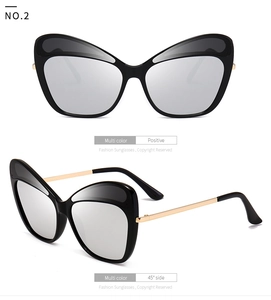 Detail view showing butterfly cat-eye sunglasses with silver lenses and gold metal temples