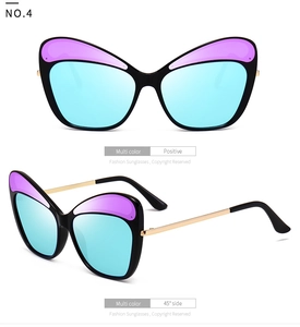Detail of cat eye sunglasses with purple gradient lenses and gold metal temples