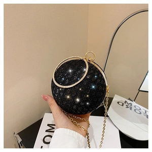 Detailed macro view of black spherical evening bag with sparkling sequins and gold handle