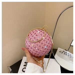 Detail of pink rhinestone spherical evening bag with golden round handle and chain strap