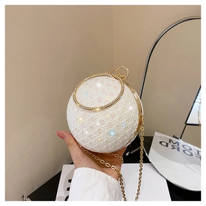 Detailed view of spherical evening bag with iridescent sequins and diamond ring handle