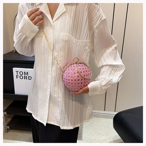 Pink rhinestone ball evening bag featuring golden metal ring handle and chain strap