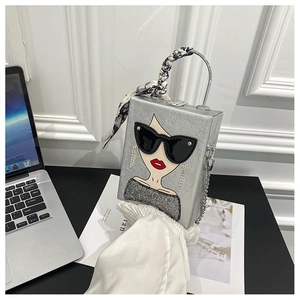 Detail of silver box bag with sequined female motif and silk scarf wrapped handle