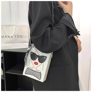 Detail of white box bag with fashion girl illustration and silver chain shoulder strap