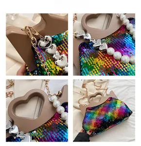 Detail of colorful gradient sequin tote bag with heart-shaped handle and pearl strap