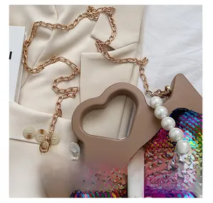 Close-up of multicolored sequins, golden chain strap and large pearls on a tote bag