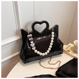 Detail of black sequin tote bag with heart-shaped handle and white pearl chain strap