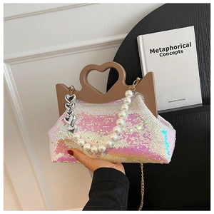 Close-up of heart-shaped handle and shimmering sequin texture with pearl and metal chains