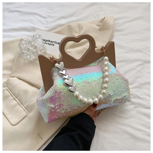 Detail of iridescent sequin tote bag with heart-shaped handle and pearl chain