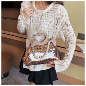 Detail of champagne gold sequin tote with heart handle and pearl tassel chain