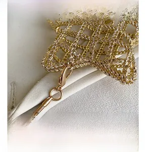 Detailed close-up of golden metal mesh bag with lobster clasp and snake chain texture