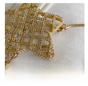 Detailed close-up of golden metal star mesh bag with lobster clasp and snake chain
