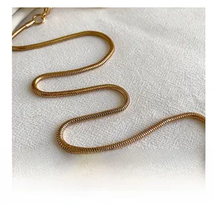 Detail of high-gloss gold snake bone chain showing delicate metal texture and craftsmanship