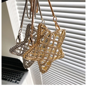 Close-up of hollow star metal weave bag with snake chain straps in gold and silver