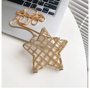 Detailed view of a gold hollow star-shaped metal bag with sleek snake bone chain strap