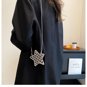 Detailed view of a silver star-shaped crossbody bag with sparkling metal mesh and chain