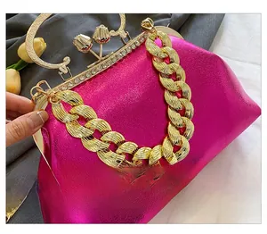 Detail of bright pink evening bag with gold chain and rhinestone tulip clasp