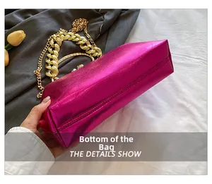 Macro view of metallic fuchsia handbag with thick gold chain and smooth bottom detail