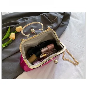 Interior capacity show of fuchsia evening bag with makeup items and gold handle