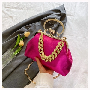 Detail of rose red evening bag with gold chain, tulip clasp and rhinestone trim