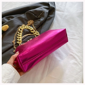 Detail shot of fuchsia metallic PU leather bag with decorative chunky gold chain and stitching