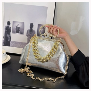 Detail of silver glitter evening bag with hollow golden ring handle and chunky chain