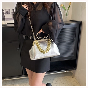 Detail of silver metallic shell bag with chunky chain strap and gold hardware accents