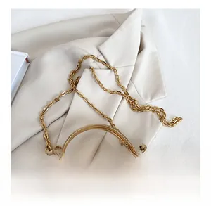 Detail of champagne evening bag with pearl accents and gold metal chain strap