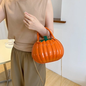 Chic orange pumpkin shaped handbag with gold chain strap and green leaf handle design