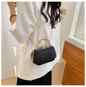 Detail of black glitter evening bag with pearl clasp and rhinestone top handle