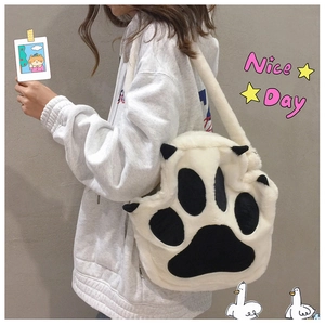 Close-up of plush cat paw shoulder bag in black and white with soft faux fur texture