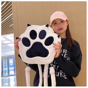 Detail of plush cat paw backpack in black and white with soft 3D toe beans and ears