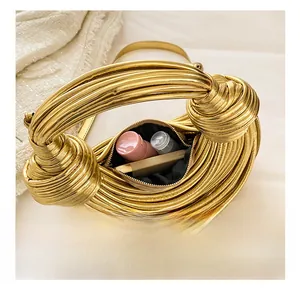 Macro shot showing internal capacity of the woven gold clutch with cosmetics inside