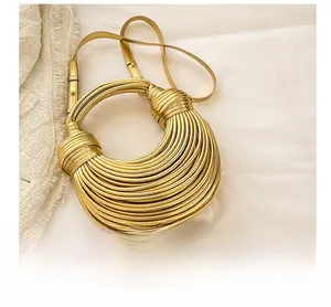 Detail of gold braided handbag with metallic texture and adjustable shoulder strap