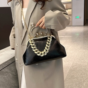 Glossy black kiss-lock handbag with chunky gold chain and rhinestone detail