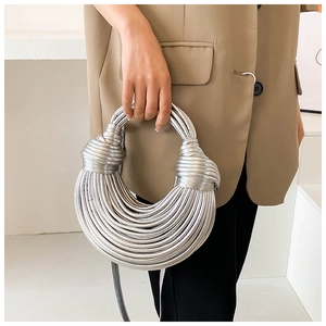 Macro detail of the woven knot and silver metallic tubing on this designer handbag