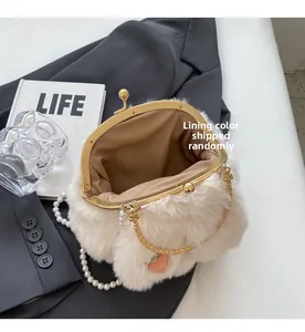 Detail of white faux fur bag showing metal clasp, pearl chain, and strawberry charm