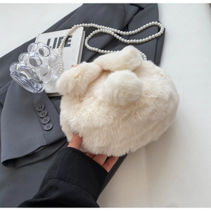 Close-up of white plush rabbit bag with soft bunny ears and premium pearl chain strap