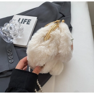 Detailed macro view of white plush bunny bag texture with elegant gold kiss-lock clasp