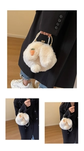 Close-up of white plush bunny bag with carrot embroidery and elegant pearl handle straps