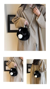 Detail of cute black plush bunny bag with pink carrot embroidery and pearl strap