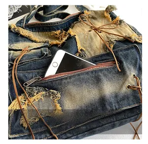Detail view of denim bucket bag showing a secure anti-theft zipper pocket with phone storage