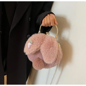 Detail of pink plush rabbit bag with gold handle, pearl strap and carrot embroidery