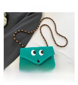Détail du mini sac en toile verte avec de grands yeux de dessin animé et bandoulière